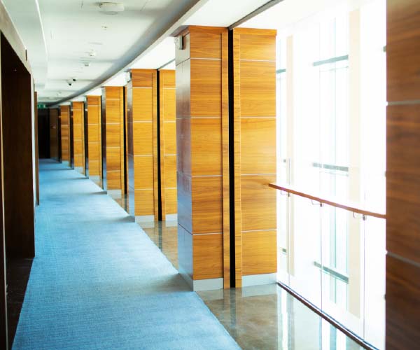 Woodgrain column design using Belbien architectural film along a hallway.